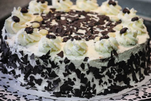 Black and white cake with buttercream frosting and chocolate ganache filling.
